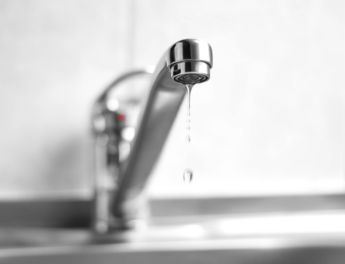 Water is dripping from a metal water tap. Close up Water is dripping from a metal water tap. Close up