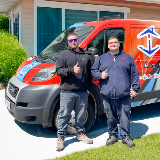 Anchor Home Comfort Plumbing technician standing by our famous green trucks in a residential neighbourhood.